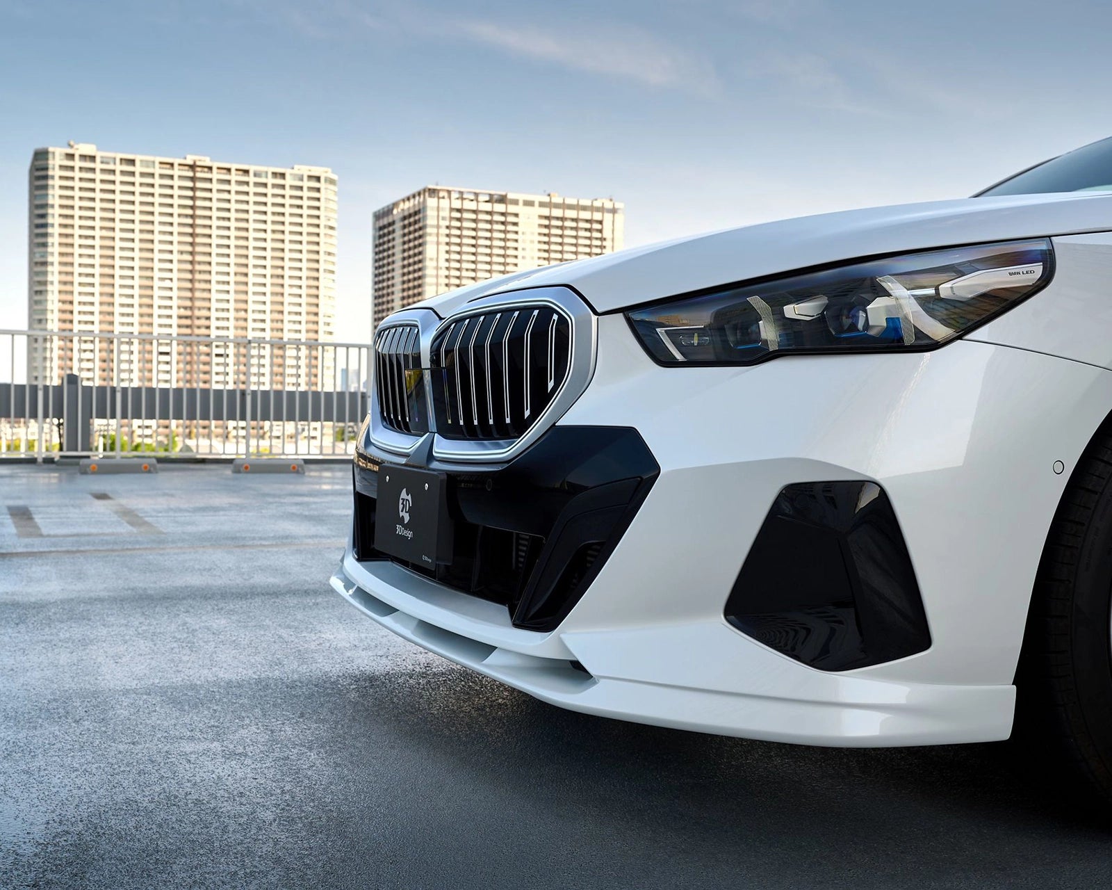 Low-angle detail of the 3DDesign urethane front lip spoiler on a BMW G60 M Sport
