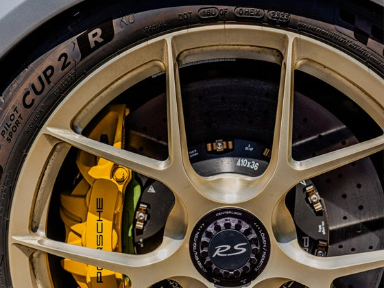 Close-up of a Porsche car wheel with PCCB brake caliper and manthey brake pads and rim details.