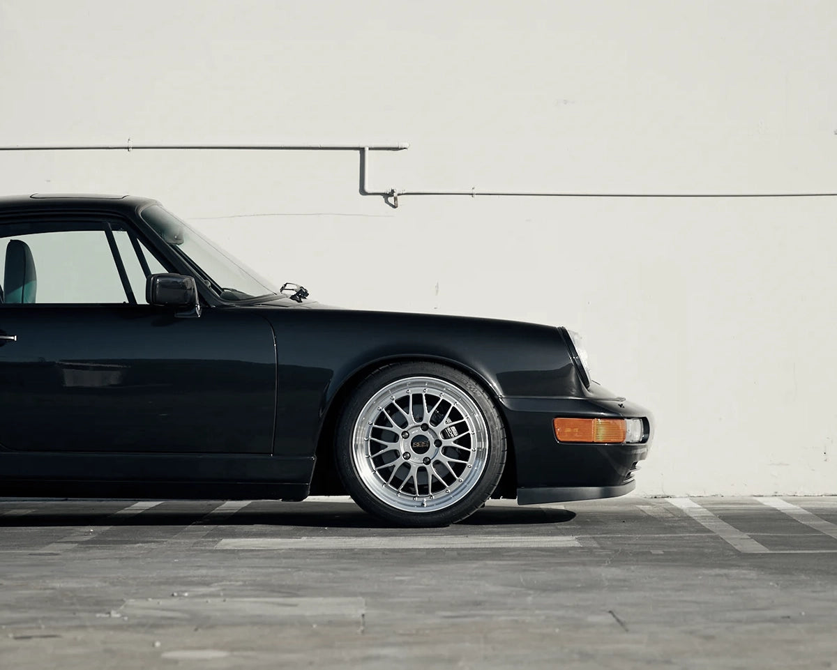 Close-up of the silver BBS LM front wheel fitted to a black narrow-body Porsche 911 964.