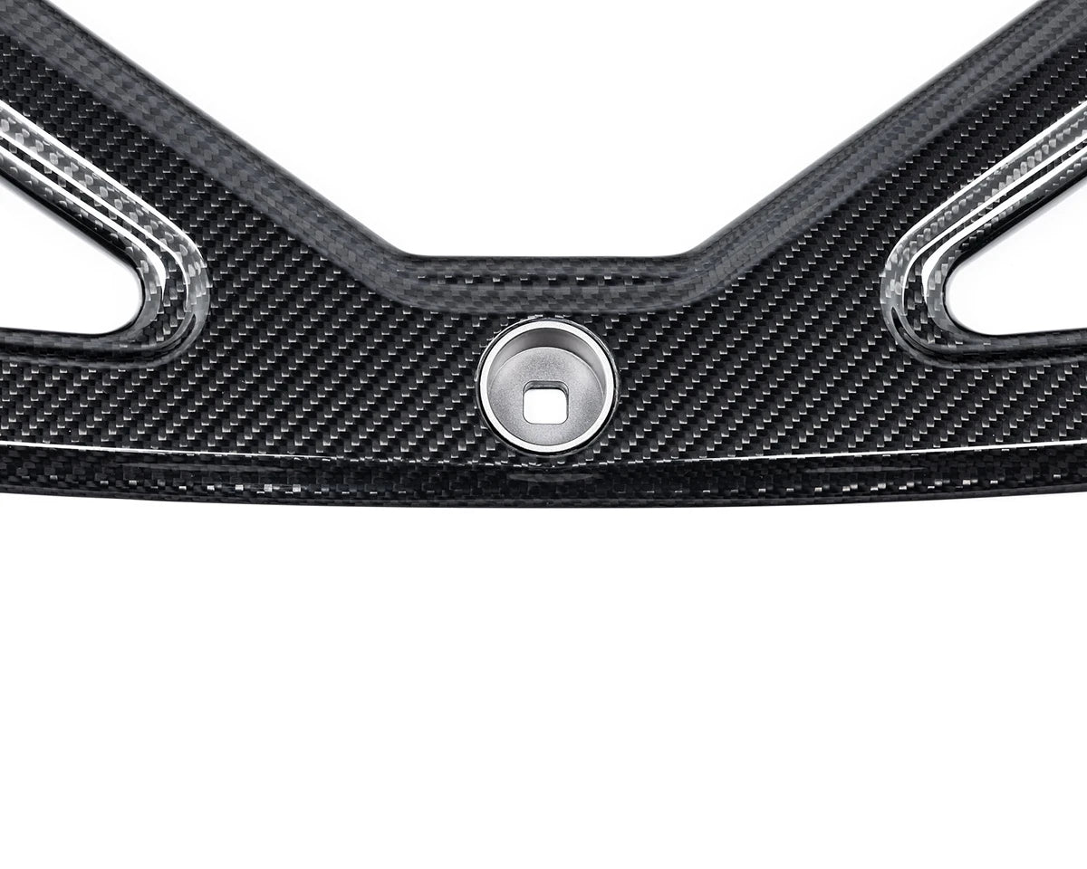 High-gloss carbon Eventuri brace mounted across BMW G87 M2 shock towers