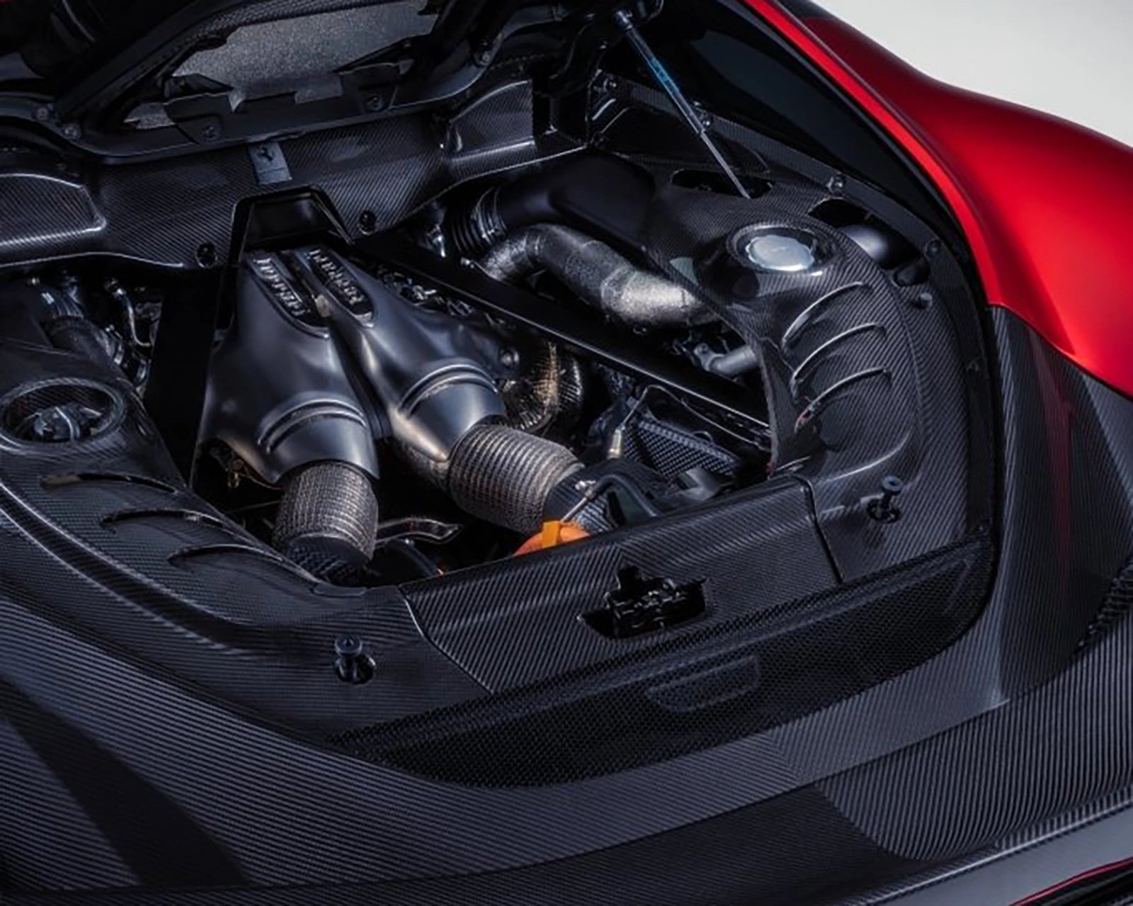 Close-up of Ferrari 296 GTB engine bay with hybrid V6 and carbon covers
