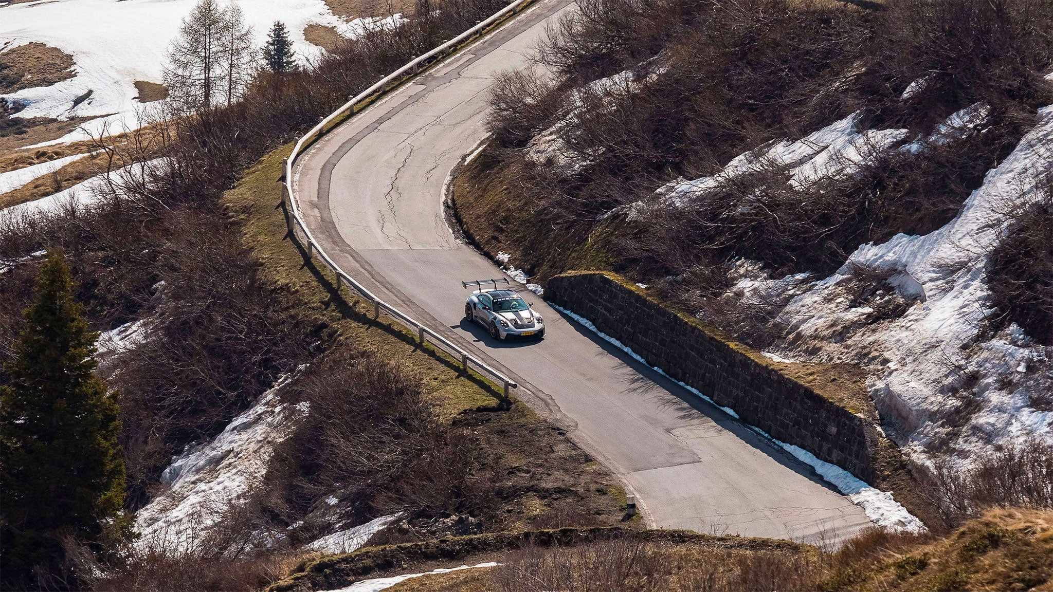 Porsche 992 GT3 RS driving through the mountains, mobile version